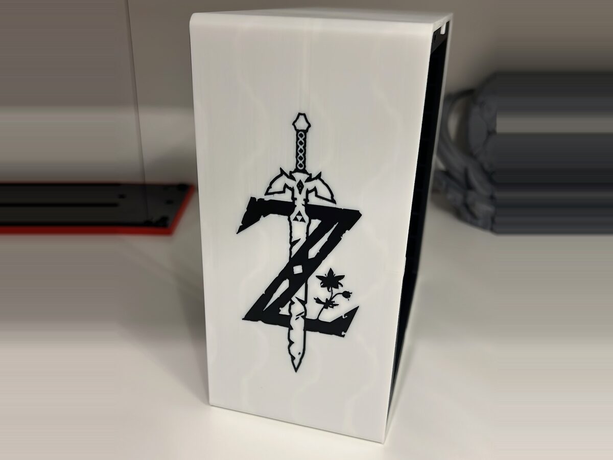 Torre organizadora de juegos impresa en 3D en blanco, con un emblema en negro a dos colores en el frontal